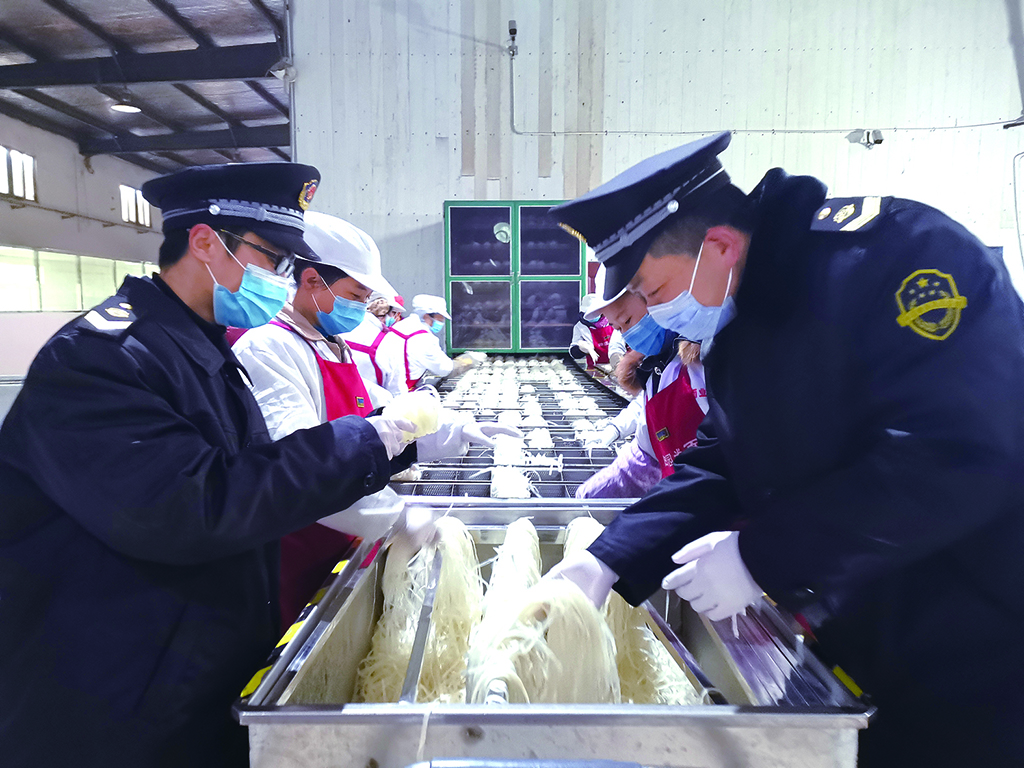 枞阳县市场监管局执法人员在车间察看食品操作流程